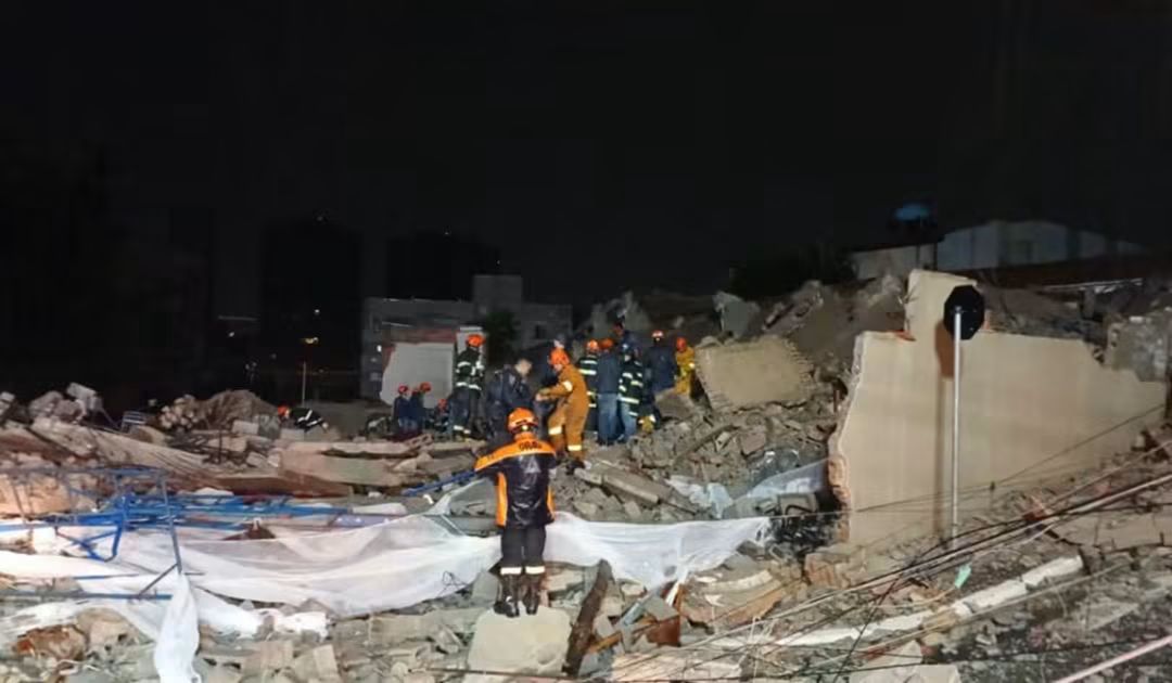 Prédio de 12 andares desaba sobre casa, deixa dois mortos e seis desaparecidos em São Paulo  Um prédio em construção, de aproximadamente 12 andares, desabou sobre uma casa durante a madrugada deste sábado (12), na Rua Tequici, no bairro da Penha, zona leste de São Paulo. O acidente deixou duas pessoas mortas, entre elas uma mulher grávida.  Duas vítimas foram resgatadas com vida pelo Corpo de Bombeiros e encaminhadas ao Hospital do Tatuapé. As equipes de emergência ainda procuram seis pessoas que podem estar sob os escombros — quatro moradores da residência e dois vigilantes que estariam no local.  Cerca de 60 bombeiros e 21 viaturas participam das buscas.  O desabamento ocorreu durante uma madrugada de chuva forte na capital paulista. Apesar das condições climáticas, as causas da queda ainda serão investigadas.  Segundo o governador Tarcísio de Freitas, informações preliminares apontam possíveis irregularidades na obra, incluindo a construção de andares além do que havia sido autorizado no projeto.  A Prefeitura de São Paulo informou que o imóvel já havia sido alvo de fiscalizações e de uma ação judicial por construção irregular. Em 2021, uma decisão determinou a paralisação das obras e a demolição de uma estrutura não autorizada.  Em 2023, um novo projeto recebeu alvará de execução, condicionado à demolição da estrutura anterior. A Prefeitura afirma que a exigência foi cumprida e confirmada em vistoria realizada em fevereiro de 2024.  Foto: CBSP